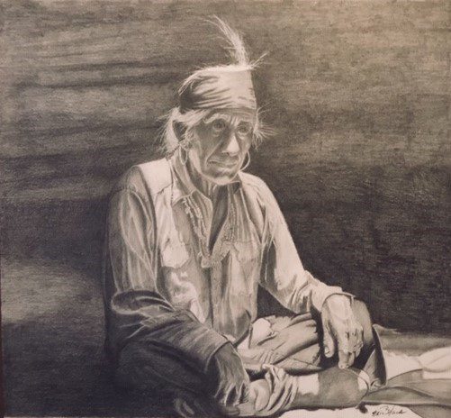 A man sitting on the ground with his head down.