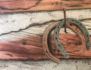 A close up of two horse shoes on top of wood.